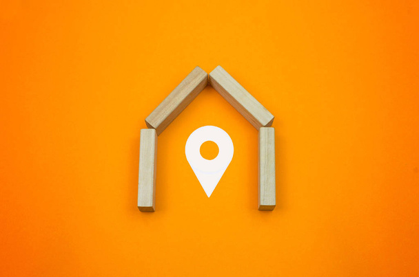 Concept of point, locate house with wooden blocks and orange background and drawing elements - Photo, Image