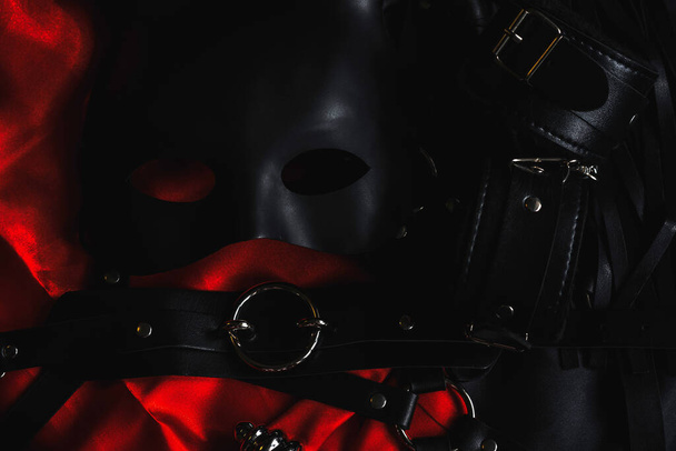 top view of the Black Mask, leather whip and dark furry handcuffs and belt - Foto, Bild