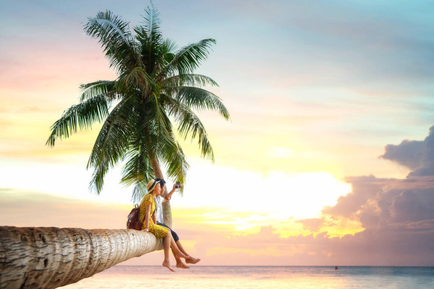 Asian couple sit on coconut tree - Fotografie, Obrázek