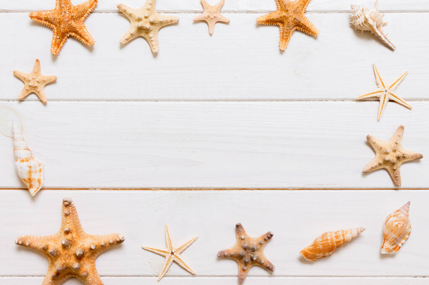 Pose plate de divers coquillages et étoiles de mer sur une table en bois blanc
, - Photo, image