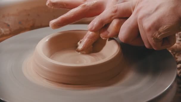 陶器-指を持つマスターは、粘土ボウルの底を作っています - 映像、動画