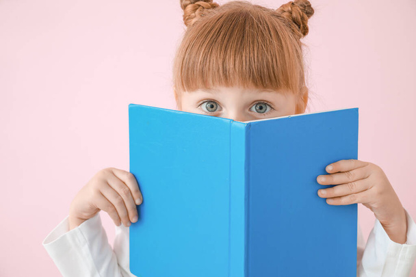 Cute little girl with book on color background - Fotografie, Obrázek