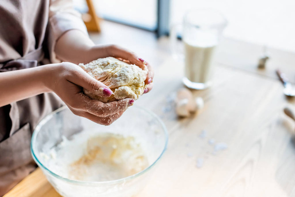 cropped view of woman holding dough in hands  - Foto, immagini