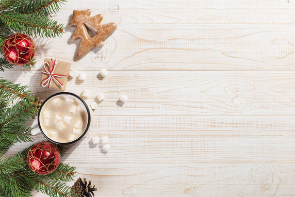 Bebida caliente de Navidad con malvaviscos en una taza de hierro y galletas de jengibre, sobre una mesa blanca. Año Nuevo, fondo de vacaciones, espacio de copia de la tarjeta de felicitación
. - Foto, imagen