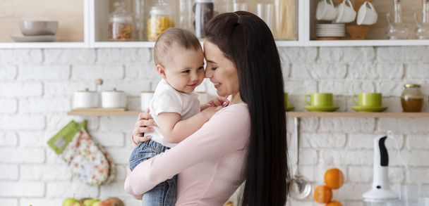 Το μωρό και η μαμά του αγκαλιάζονται στην κουζίνα, πανόραμα - Φωτογραφία, εικόνα