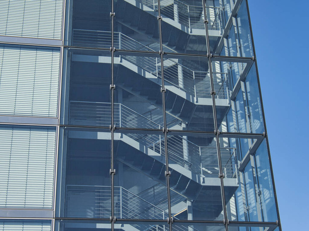 Un escalier ouvert derrière une façade en verre
 - Photo, image