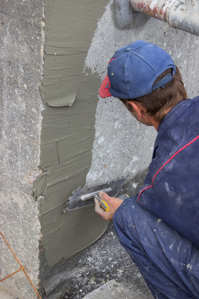 Bauarbeiter verteilt Mörtel auf Betonwand 2 - Foto, Bild