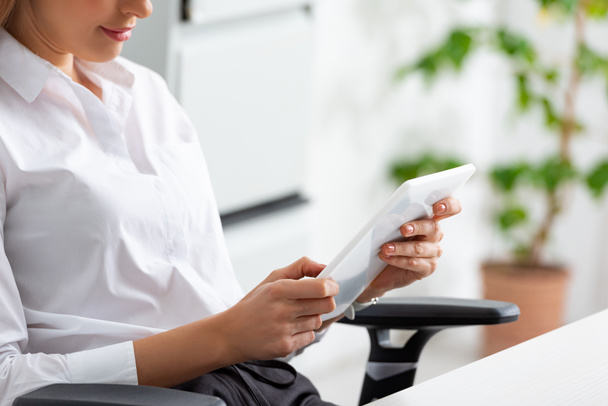 Vue recadrée de femme d'affaires en utilisant une tablette numérique dans le bureau
  - Photo, image