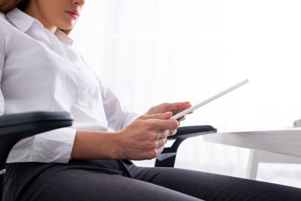 Vue à faible angle de la femme d'affaires en utilisant une tablette numérique tout en étant assis à table
 - Photo, image