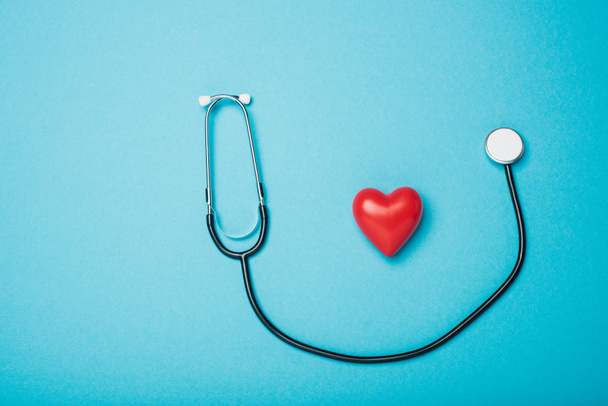 Top view of decorative red heart and stethoscope on blue background, world health day concept - Fotografie, Obrázek