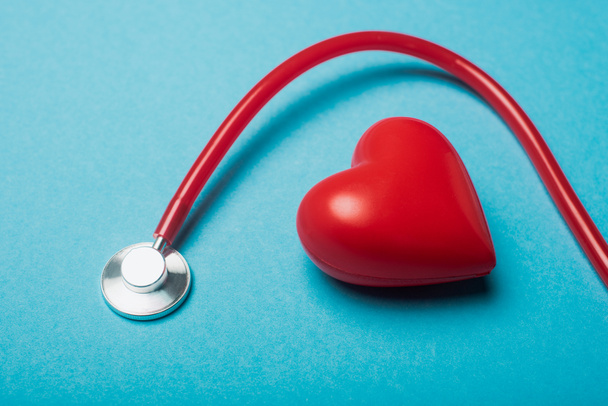 Corazón decorativo y estetoscopio rojo sobre fondo azul, concepto del día mundial de la salud
 - Foto, Imagen