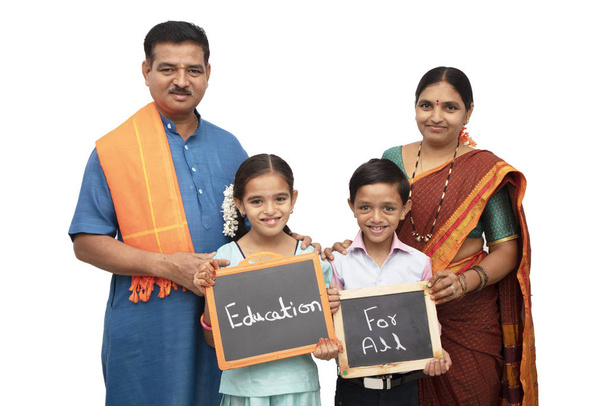 Concept of Education for all children holding slate with traditional Indian family on isolated background - Fotoğraf, Görsel