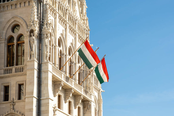 Drapeaux hongrois sur le bâtiment du Parlement hongrois ou Parlement de Budapest, une destination touristique historique et populaire à Budapest, Hongrie - Photo, image