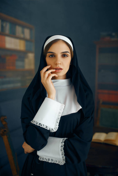 Young sexy nun in a cassock, vicious desires. Corrupt sister in the monastery, religion and faith, sinful religious people, attractive sinner - Фото, зображення