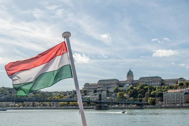Vue du château de Buda et de la ville avec le Danube et le drapeau hongrois flou à Budapest, Hongrie
. - Photo, image