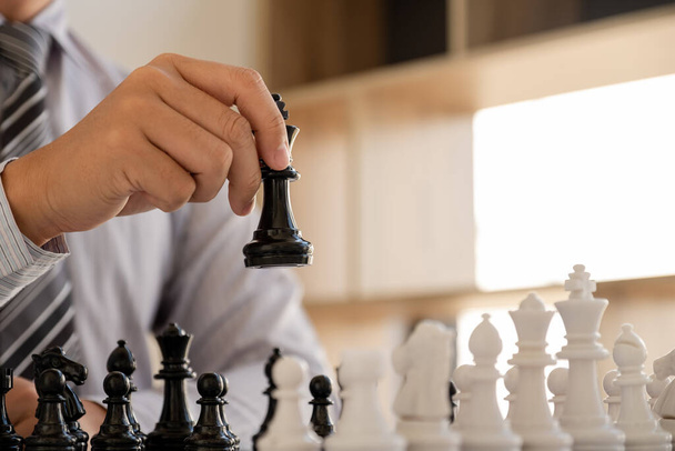 hand of businessman moving chess in competition, shows leadership, followers and business success strategies - Φωτογραφία, εικόνα