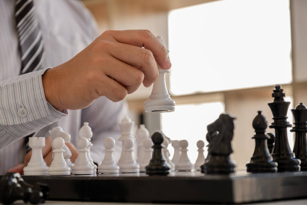 mão de homem de negócios movendo xadrez em competição, mostra liderança, seguidores e estratégias de sucesso de negócios
 - Foto, Imagem
