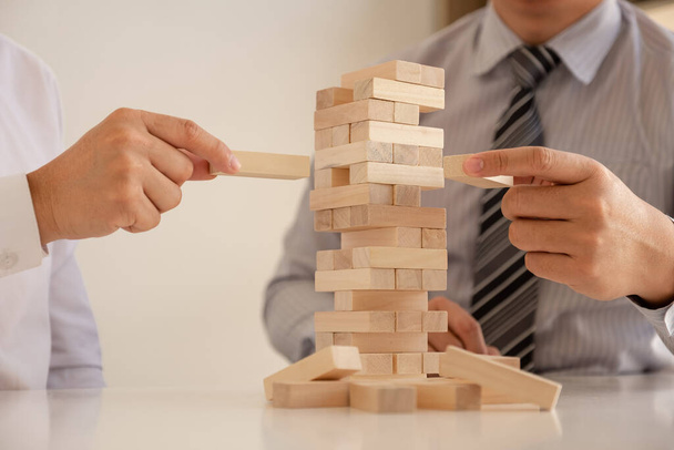 Immagine di mano blocca gioco di legno per crescere del business. Piano di gestione e strategia del rischio
 - Foto, immagini