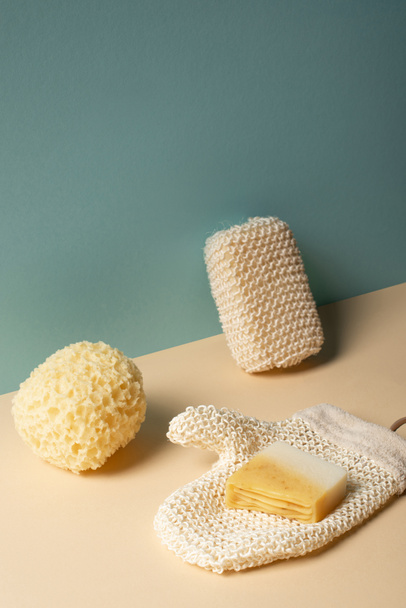 Eponges, gant exfoliant avec savon beige et gris, concept zéro déchet
 - Photo, image