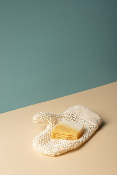 Перчатка для ванны с мылом на бежевом и сером, концепция нулевых отходов
  - Фото, изображение