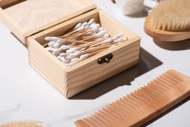 Selective focus of box of ear sticks, comb and Hair brush on white background, zero waste concept - 写真・画像