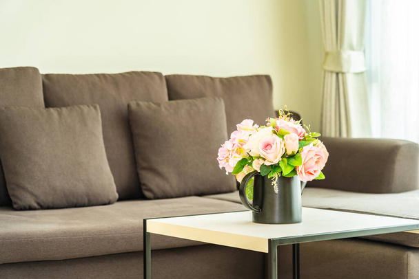 Βάζο λουλούδι στο τραπέζι με μαξιλάρι και καναπέ διακόσμηση εσωτερικό - Φωτογραφία, εικόνα