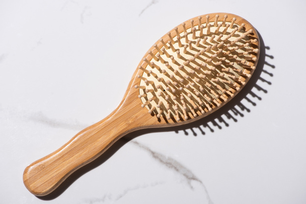 Vue du dessus de la brosse à cheveux en bois sur fond blanc, concept zéro déchet
 - Photo, image