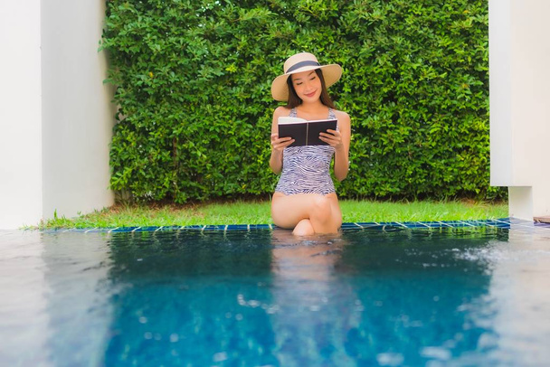Güzel bir Asyalı kadının portresi. Yüzme hakkında kitap okuyor. - Fotoğraf, Görsel