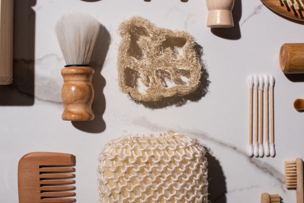 Top view of comb, toothbrushes, ear sticks, sponges, shaving brushes on white background, zero waste concept - 写真・画像