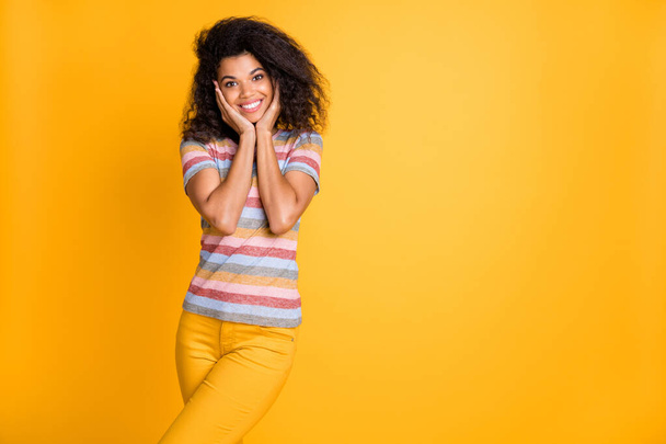 Portrait of her she nice attractive glad cheerful cheery wavy-haired girl wearing striped tshirt touching face enjoying good news isolated over bright vivid shine vibrant yellow color background - Foto, Bild