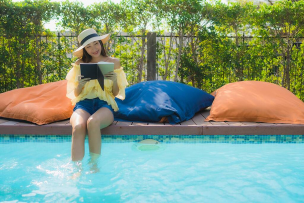 Портрет молодой азиатской женщины читать книгу вокруг открытых какашек плавания
 - Фото, изображение