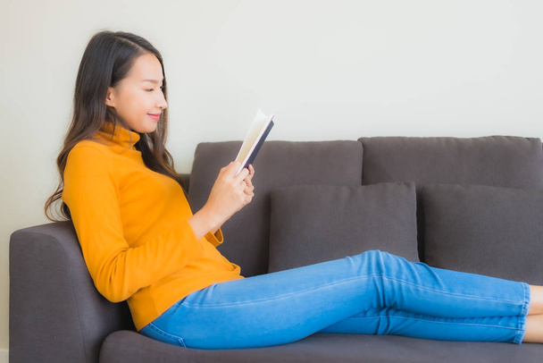 Muotokuva nuori aasialainen nainen lukea kirjaa sohva tuoli tyyny i
 - Valokuva, kuva