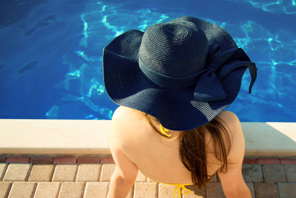woman it hat relaxing at the pool - Foto, afbeelding