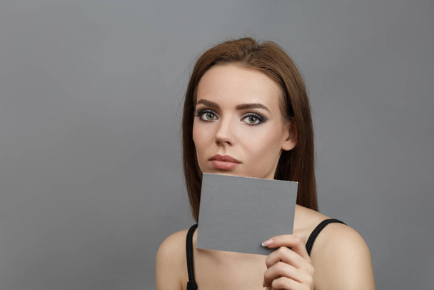Beautiful woman with brown hair holds a sheet - Fotografie, Obrázek
