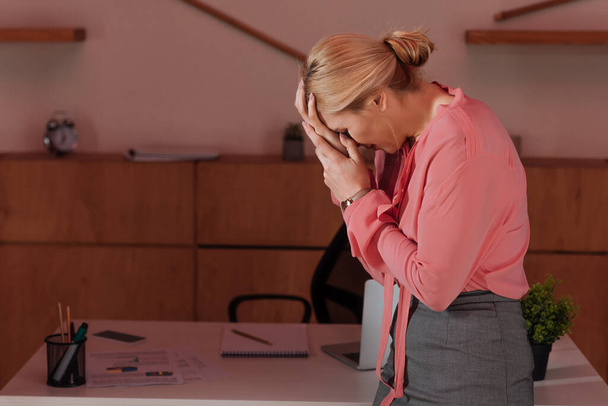 Вибірковий фокус жінки, що закриває обличчя і плаче в офісі
 - Фото, зображення