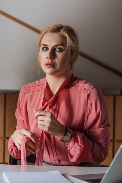 Selective focus of Victim holding ribbons on blouse in office, sexual harassment concept - Zdjęcie, obraz
