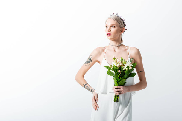 beautiful tattooed bride with bouquet looking away isolated on white - Fotoğraf, Görsel