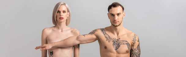 young naked tattooed couple isolated on grey, panoramic shot - Foto, afbeelding