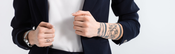 oříznutý pohled na úspěšnou mladou tetovanou podnikatelku s rukama na blejzru izolovaném na bílém panoramatickém záběru - Fotografie, Obrázek