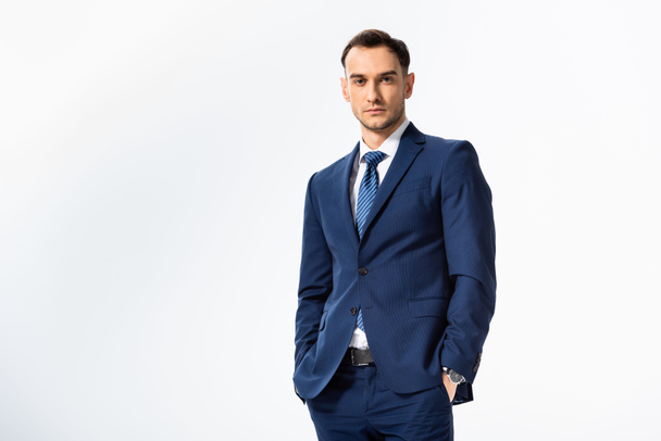 successful young businessman in blue suit with hands in pockets isolated on white - Photo, Image