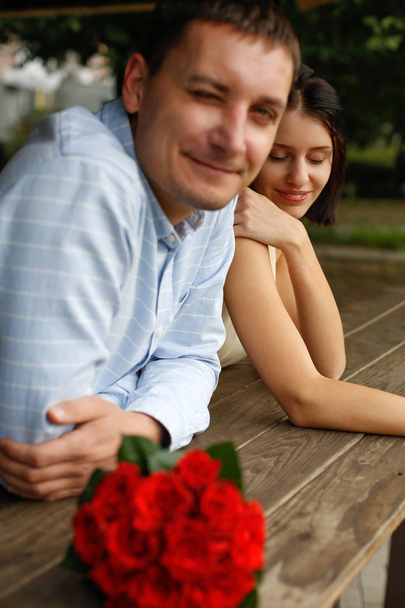 Spontané drôle jeune couple portrait wuth bouquet de roses rouges gros plan, heureux au sujet du mariage, mariage juste pour deux, clin d'oeil
 - Photo, image