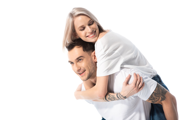 happy young tattooed couple piggybacking isolated on white - Fotó, kép