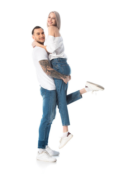 happy young tattooed man holding girlfriend isolated on white - Foto, Imagen