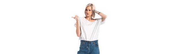 pensive young tattooed girl pointing with finger away isolated on white, panoramic shot - Foto, Bild
