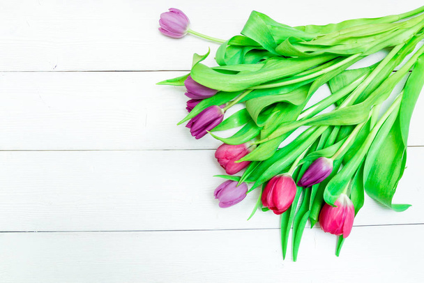 Bunch of red and purple tulips on white wooden background with copy space like postcard on womens day - Foto, Bild