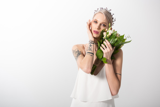 portrait of beautiful tattooed bride posing with floral bouquet on white - Zdjęcie, obraz