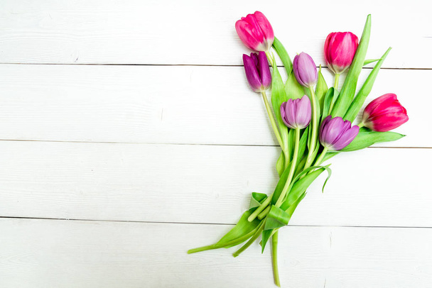 Bunch of red and purple tulips on white wooden background with copy space like postcard on womens day - Foto, Imagen