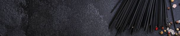 Макароны-спагетти с чернилами каракатицы (здоровое питание, черный цвет) концепции меню. пищевой фон. вид сверху. копировальное пространство
 - Фото, изображение