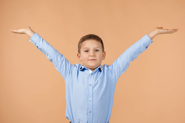 Милый счастливый улыбающийся мальчик поднимает руки вверх
 - Фото, изображение