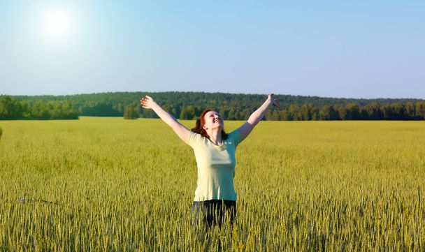 Femme à bras ouverts dans un champ vert
 - Photo, image